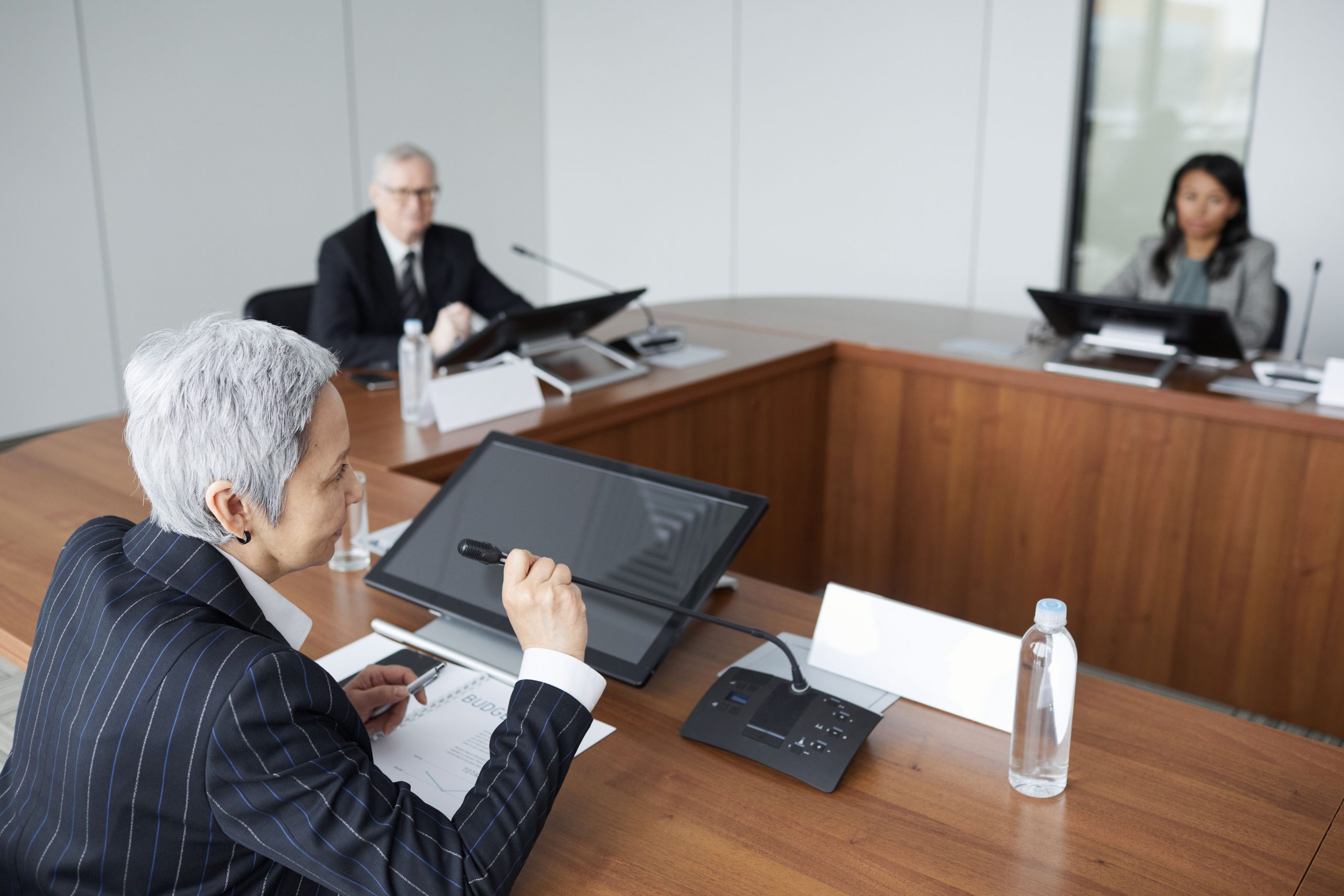 Senior executives discussing strategy in a modern boardroom, illustrating the business side of large-scale litigation