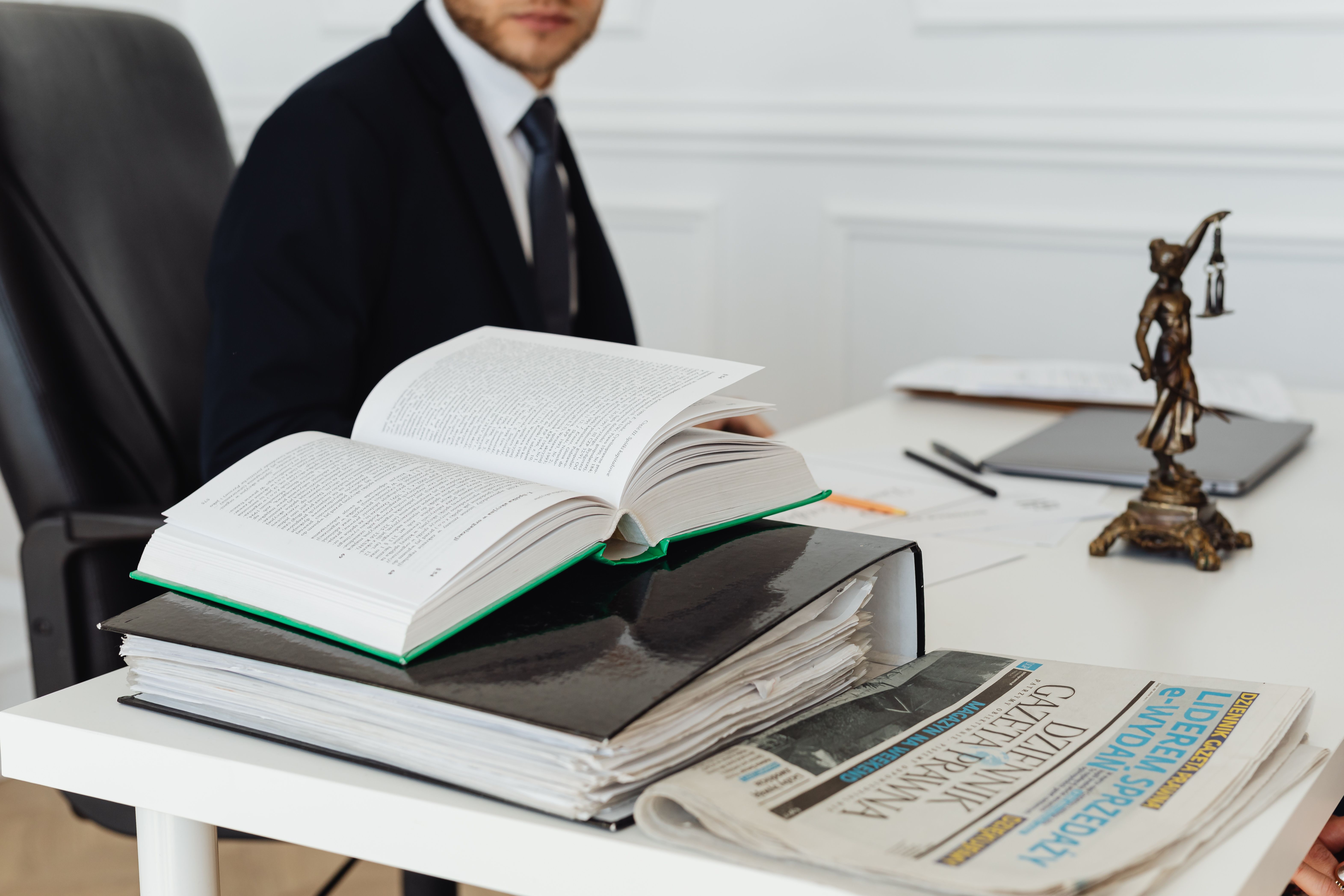Lawyer sitting at a desk with legal books and documents representing litigation law firm work